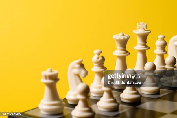 chess game with yellow background - ajedrez fotografías e imágenes de stock
