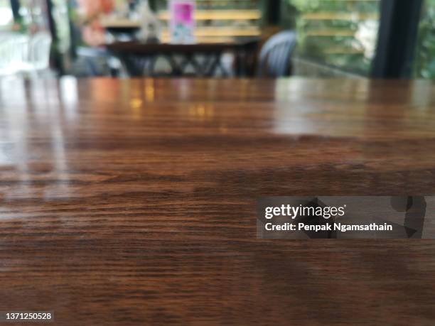 dark brown wooded table on blurred coffee shop background - mesa fotografías e imágenes de stock