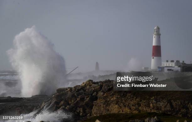 Waves crash ashore at Portland Bill lighthouse, on February 18, 2022 in Portland, England. The Met Office has issued two rare, red weather warnings...