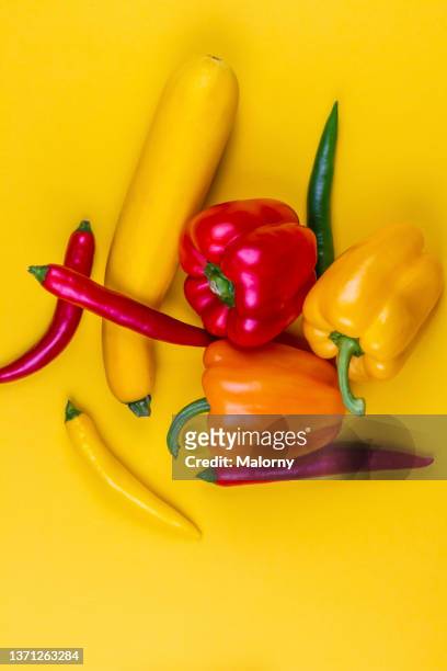 yellow, orange and red bell peppers on yellow background. - yellow bell pepper stock-fotos und bilder