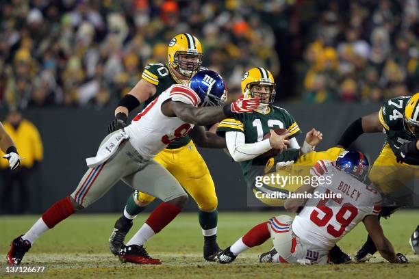 Aaron Rodgers of the Green Bay Packers gets sacked by Jason Pierre-Paul and Michael Boley of the New York Giants during their NFC Divisional playoff...