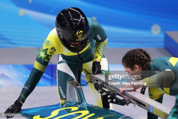 Breeana Walker and Kiara Reddingius of Team Australia work on their bobsleigh after sliding during the 2-women Bobsleigh heats on day 14 of Beijing...