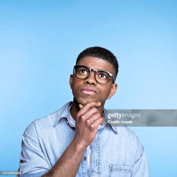 confused young man wearing denim shirt - confused person stock pictures, royalty-free photos & images