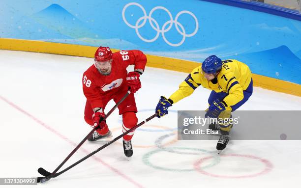 Anton Slepyshev of Team ROC is challenged by Henrik Tommernes of Team Sweden in the first period during the Men's Ice Hockey Playoff Semifinal match...