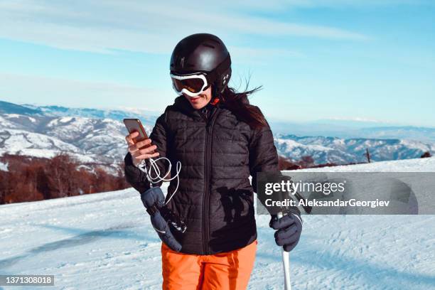 female skier setting up music playlist for skiing - snowboard bildbanksfoton och bilder