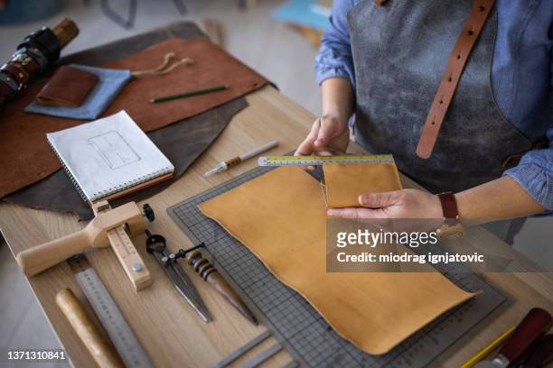 artisan working on leather crafting in her workshop - leather goods stock pictures, royalty-free photos & images