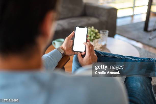 an unrecognizable man using his smartphone to order food for delivery - angle stock pictures, royalty-free photos & images
