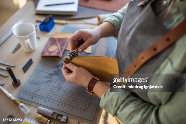 dedicated leather craftsman working in workshop - leather craft stock pictures, royalty-free photos & images
