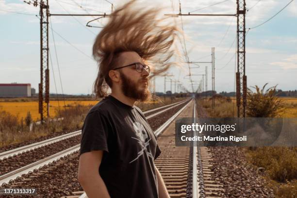 young man portrait headbanging on train tracks - head banging stock pictures, royalty-free photos & images
