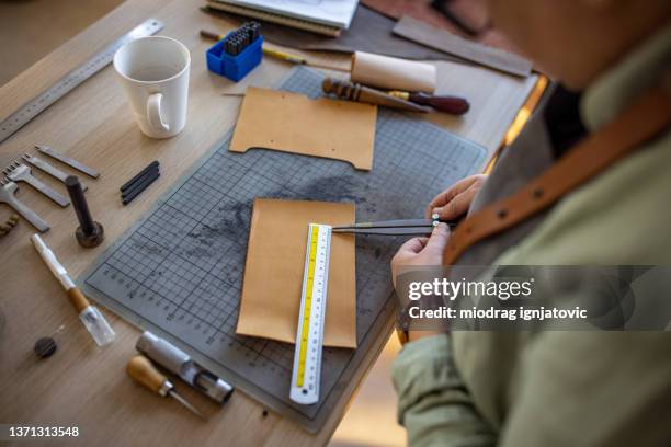 skilled leather craftsman working on new wallet in her workshop - leather craft stock pictures, royalty-free photos & images