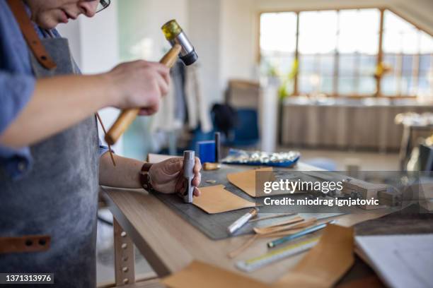 leather craftsman making handmade wallet in workshop - leather craft stock pictures, royalty-free photos & images