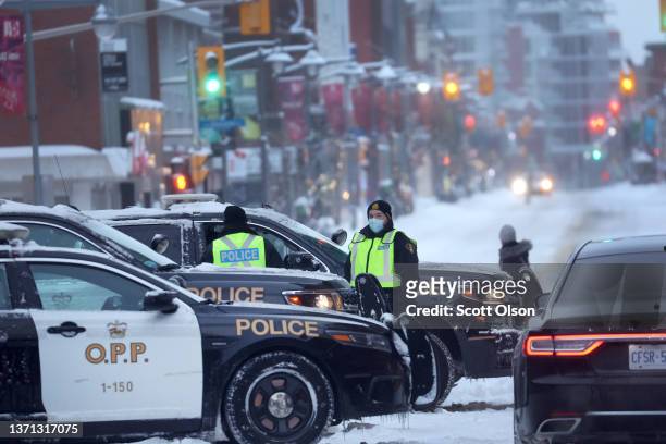 Police man a roadblock near a blockade formed by truck drivers opposing vaccine mandates near Parliament Hill on February 18, 2022 in Ottawa,...