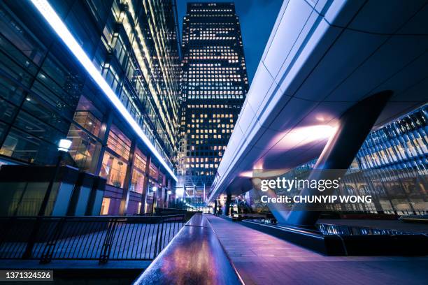 leuchtende bürogebäude in canary wharf, london at night - leerer schreibtisch stock-fotos und bilder