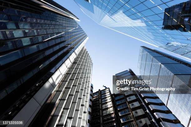 directly below shot of modern skyscrapers in the city of london - merger stock-fotos und bilder