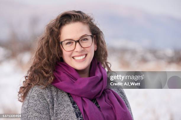 joven sonriente de pie afuera en el invierno - purple coat fotografías e imágenes de stock