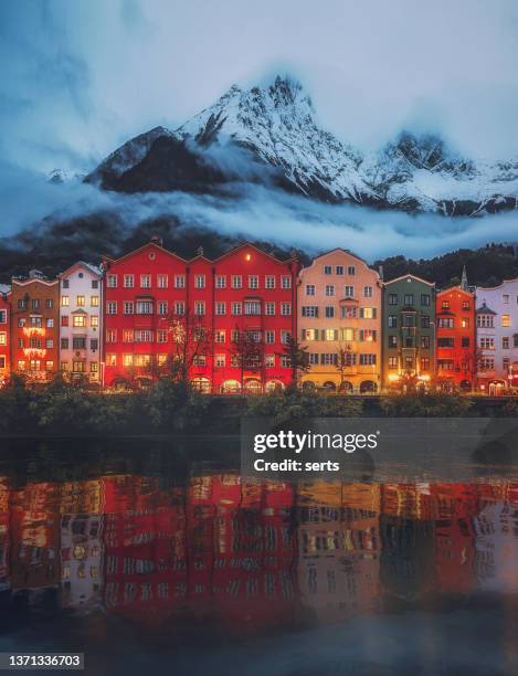 vista della città di innsbruck nel giorno d'inverno - case colorate e montagne coperte di neve con foschia nebbiosa nel centro storico della città tirolo nell'austria occidentale. - innsbruck city foto e immagini stock