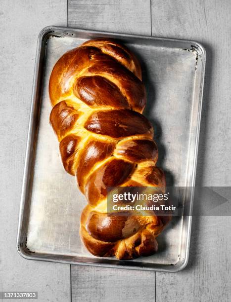 homemade braided bread on a tray on white, wooden background - treccia di pane foto e immagini stock