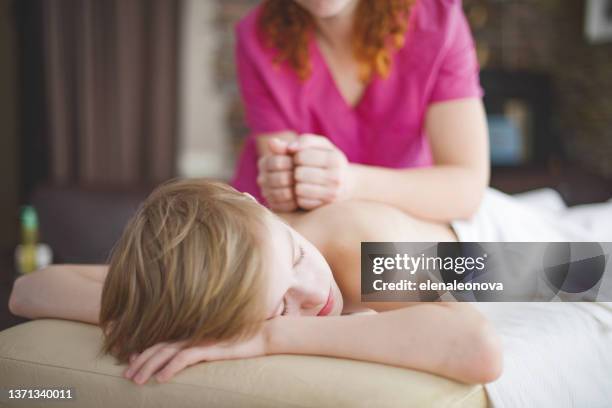 terapeuta de masaje femenino haciendo masaje al niño en casa - massage room fotografías e imágenes de stock