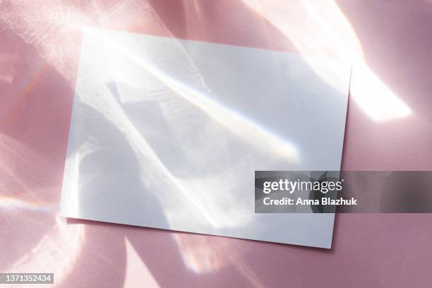 water texture overlay photo effect. white blank card for copy space. rainbow refraction of light over pink background. - flat lay photography stock-fotos und bilder