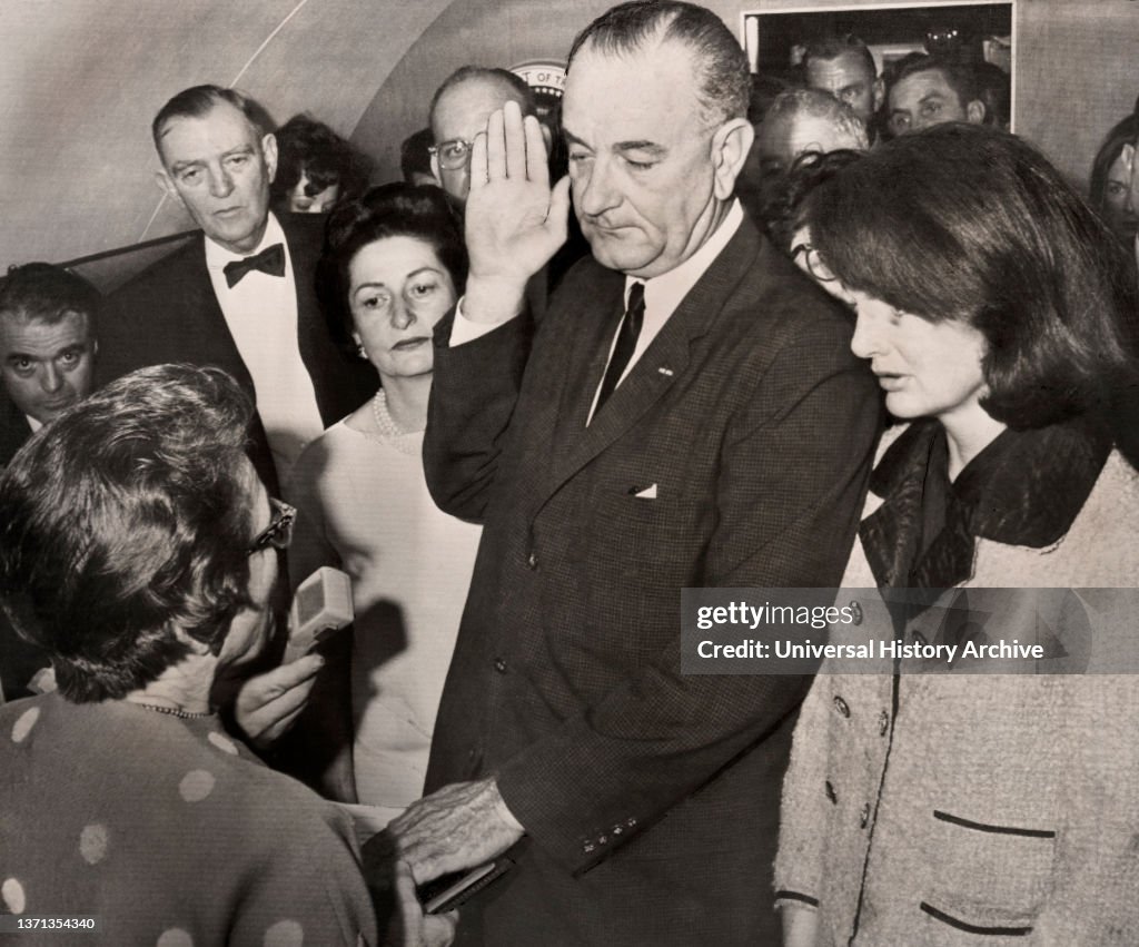 Lyndon Johnson being sworn in as U.S. President by Judge Sarah Hughes aboard Air Force One after assassination of U.S. President John F. Kennedy, First Lady Claudia "Lady Bird" Johnson and former First Lady Jacqueline Kennedy look on, Love Field Airport,