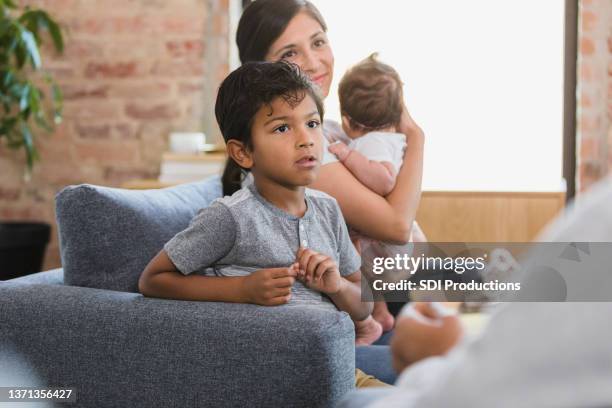 elementary age boy listens seriously to unrecognizable teacher - child psychologist stock pictures, royalty-free photos & images