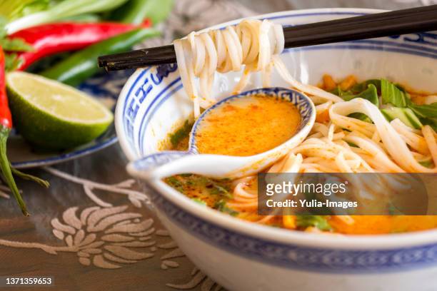 bowl of spicy asian soup with noodles - thai food stock pictures, royalty-free photos & images