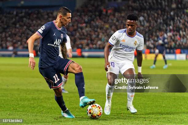 Angel Di Maria of Paris SG is challenged by Vinicius Junior of Real Madrid during the UEFA Champions League Round Of Sixteen Leg One match between...