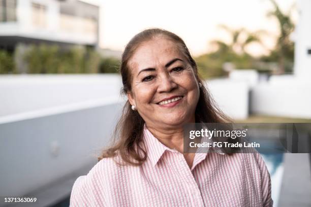 retrato de una mujer latina mayor en casa - humility fotografías e imágenes de stock
