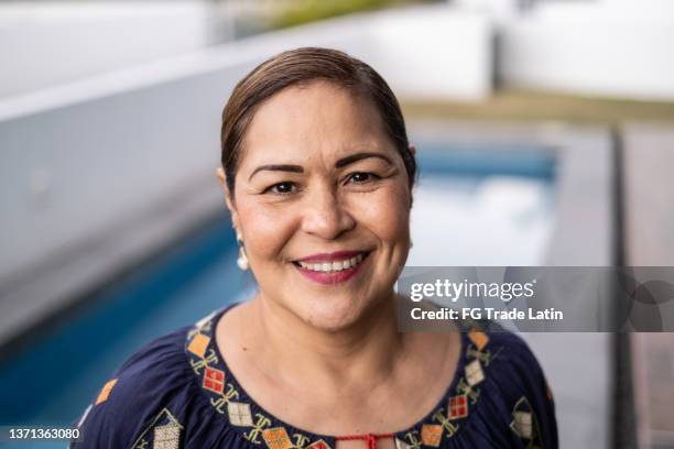 retrato de una mujer latina madura en casa - latinoamericano fotografías e imágenes de stock