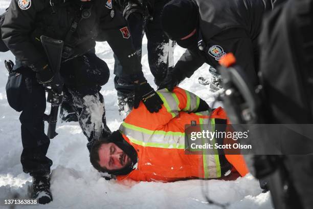 Demonstrator is taken into custody as the police begin to break up a protest organized by truck drivers opposing vaccine mandates on February 18,...