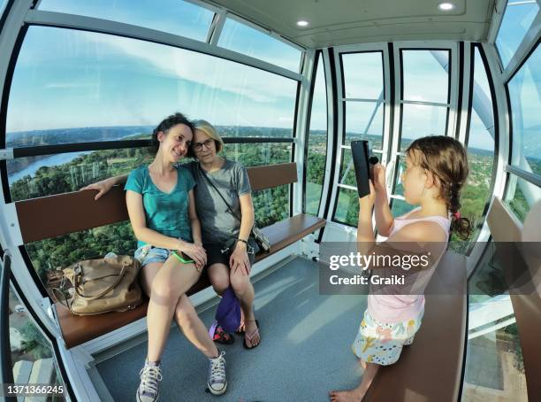 little girl making a photo of her mother and grandmother. - foz do iguacu photos et images de collection