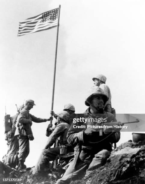 The First Iwo Jima Flag Raising. Stars and Stripes carried ashore by the 2nd Battalion, 28th Marines is planted atop Mount Suribachi at 10.20 am, 23...