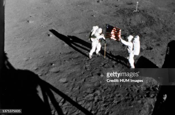 Astronaut Neil A. Armstrong, stands on the left at the flag's staff. Astronaut Edwin E. Aldrin Jr., also pictured. Pic taken by the 16mm Data...
