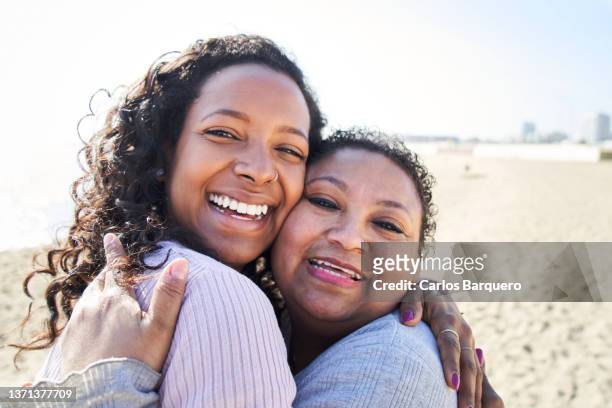 sweet photography of mother and daughter hugging and looking at camera with a cheerful face. - nichtje stockfoto's en -beelden
