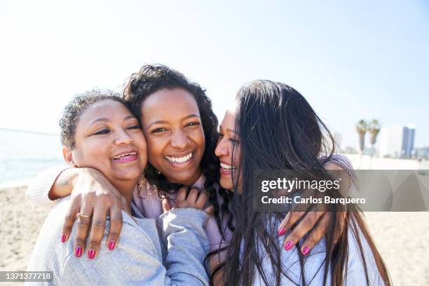 lovely portrait of family embracing each other at the beach. - barceloneta beach stock pictures, royalty-free photos & images