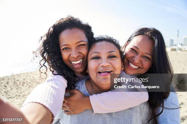 happy selfie of three women of diverse edges having fun on the beach. - generation x ストックフォトと画像