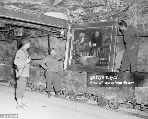 Soldiers display Edouard Manet's masterpiece 'In the Conservatory' removed by the Nazis and concealed in the Merkers salt mine, 15 April, 1945. The...