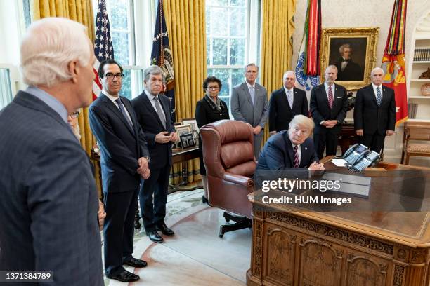 President Donald Trump listens as Sen. John Cornyn R-Texas addresses his remarks at the signing of H.R. 266 ‰ÛÒ the Paycheck Protection Program and...