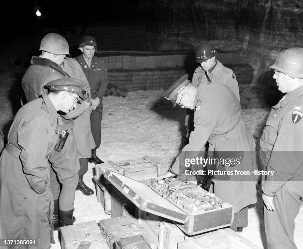 Gen. Dwight D. Eisenhower, Supreme Allied Commander, and Gen. Omar N. Bradley, CG, 12th Army Group, examine a suitcase of silverware, part of German...