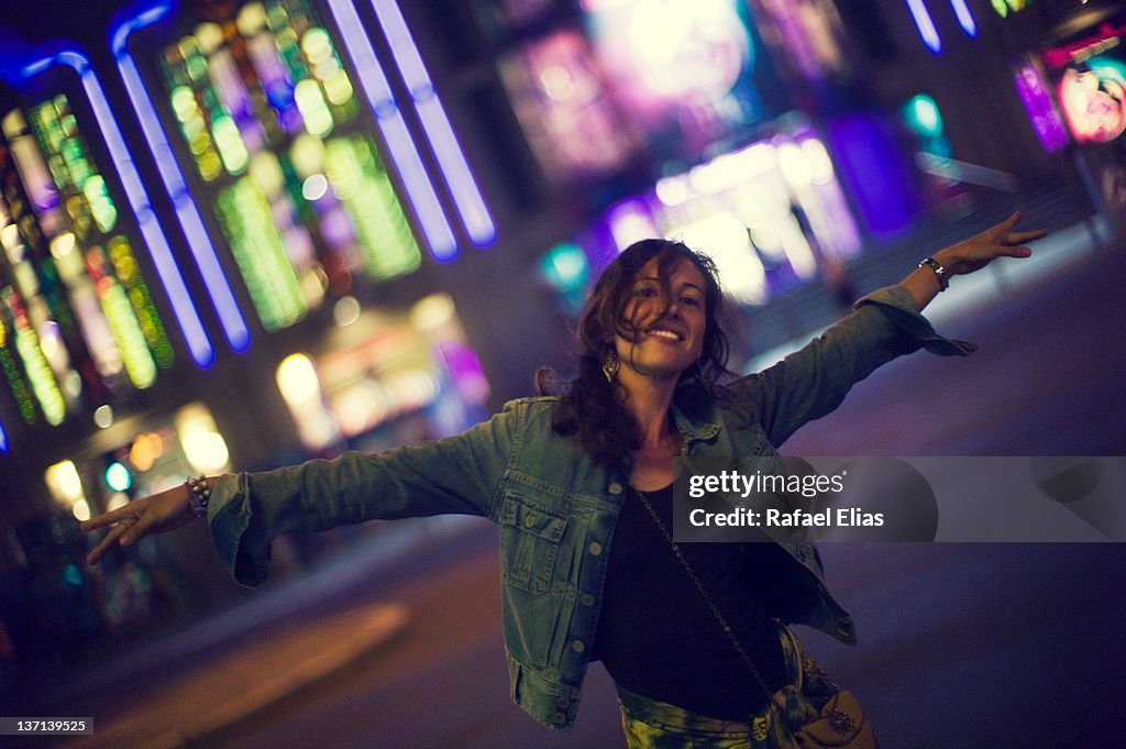 Happy woman standing on street at night