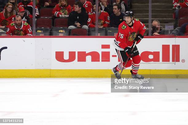 Alec Regula of the Chicago Blackhawks controls the puck during the first period against the Dallas Stars at United Center on February 18, 2022 in...