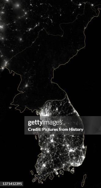 The Korean Peninsula at night, shown in a composite photograph. The amount of light is a direct indicator of economic activity distinguishing South...