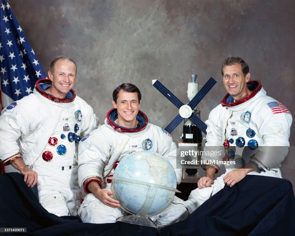 (August 1973) --- These three men are the prime crew for the Skylab 4 mission. Pictured in their Skylab spacesuits with a globe and a model of the Skylab space station are, left to right, Gerald P. Carr, Edward G. Gibson, and astronaut William R. Pogue, p