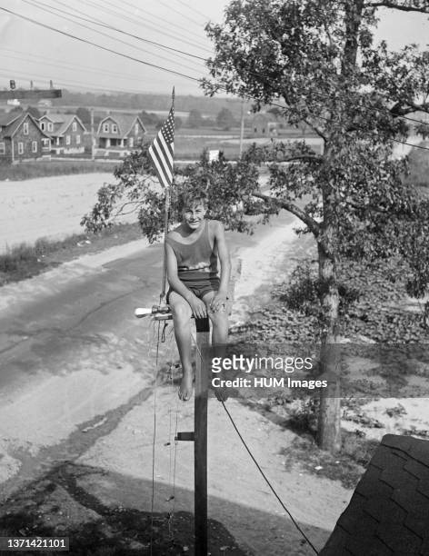 William Ruppert, 14-year-old youth of Colgate, Maryland, as he appeared atop the flag pole in the yard of his home yesterday after breaking the pole...