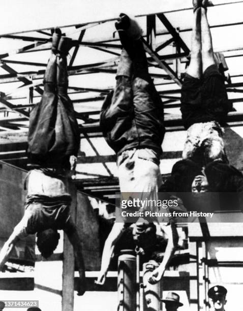 The bodies, left to right, of Achille Starace, former secretary of the Fascist Party, Benito Mussolini and his mistress, Clara Petacci, hang from a...