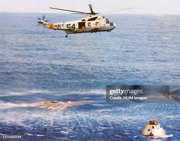 Immediately after splashdown a recovery helicopter from the USS Guadalcanal hovers over the Apollo 9 spacecraft.