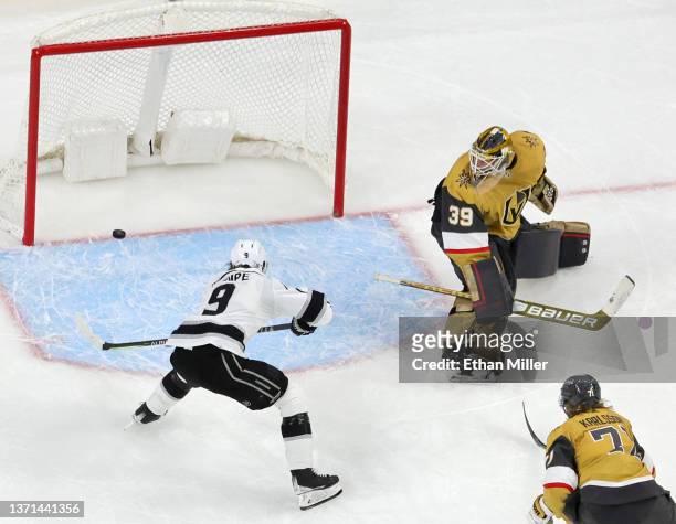 Adrian Kempe of the Los Angeles Kings scores a goal in overtime against Laurent Brossoit and William Karlsson of the Vegas Golden Knights to win...