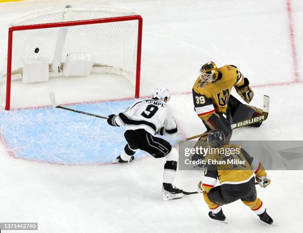 Adrian Kempe of the Los Angeles Kings scores a goal in overtime against Laurent Brossoit and William Karlsson of the Vegas Golden Knights to win...