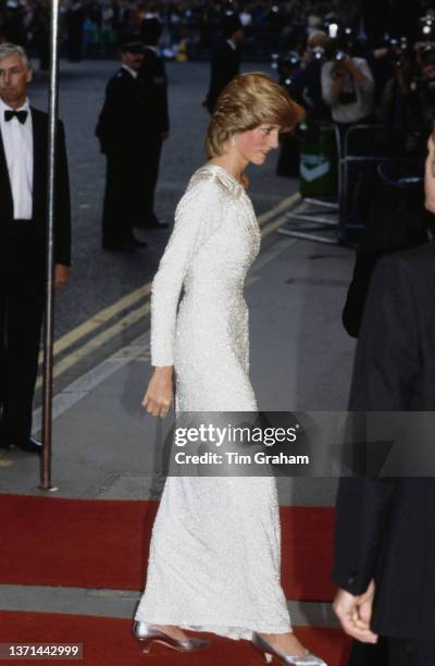 British Royal Diana, Princess of Wales , wearing a white Hachi one-shoulder evening gown, attends for the London premiere of 'Octopussy,' held at the...