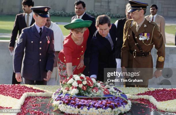 Diana, Princess of Wales , wearing a red top with gold buttons and a green hat with an upturned brim, and her husband Charles, Prince of Wales with...